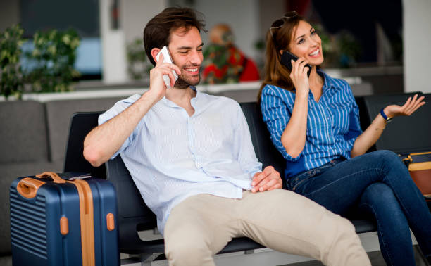 istock Couple using smart phones at airport terminal 1157321452