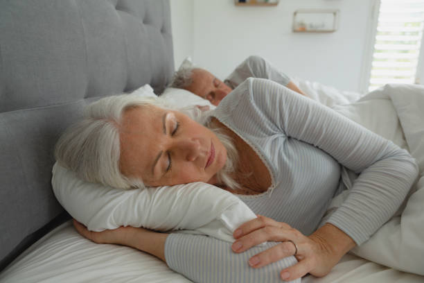 istock Active senior couple sleeping together in bed in bedroom 1157324671