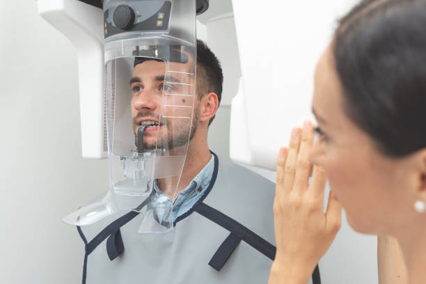 paziente in piedi in una macchina a raggi x presso la clinica dentale - scansione scientifica foto e immagini stock