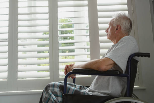 istock Active senior man in wheelchair looking through window at home 1157324914
