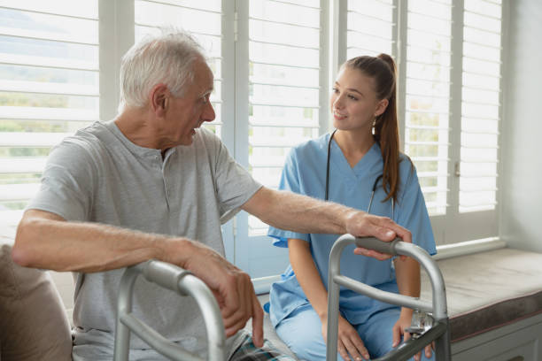 istock Female doctor interacting with active senior man on window seat 1157325838
