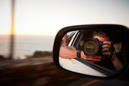 Man With Camera Taking Photo In Car Wing Mirror