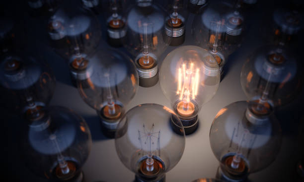Glowing Light Bulb Standing Out From the Crowd Glowing Light Bulb between the others. Can be used leadership, innovation and individuality concepts.  (3d render) innovation individuality standing out from the crowd contrasts stock pictures, royalty-free photos & images