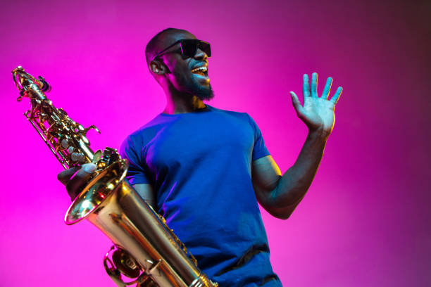 молодой афро-американский джазовый музыкант играет на саксофоне - cool jazz стоковые фото и изображения