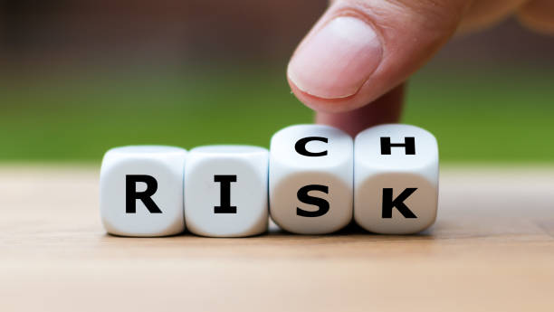 istock Take a risk and getting rich concept. Hand turns dice and changes the word 