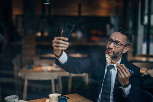 istock Man eating sushi and taking selfie 1157327643