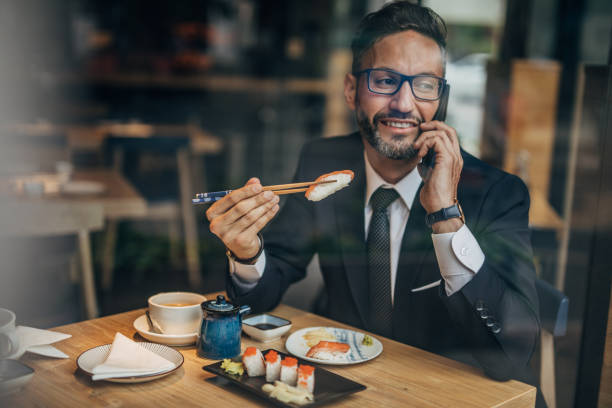 istock Businessman having lunch and talking on phone 1157329236