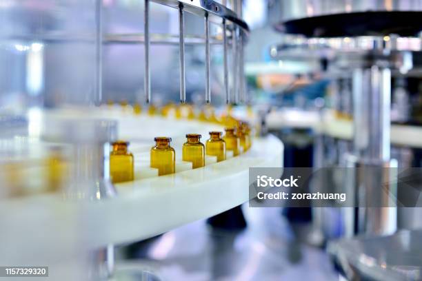 Brown Glass Bottle Filling At Production Line Stock Photo - Download Image Now - Medicine, Industry, Healthcare And Medicine