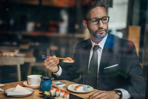 istock Serious businessman having sushi 1157329571