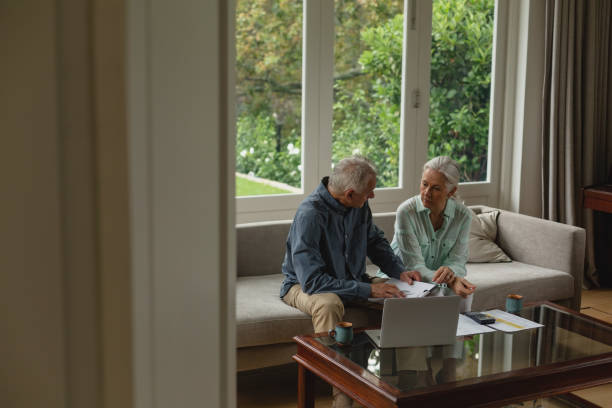 istock Active senior couple calculating bills in living room 1157332496