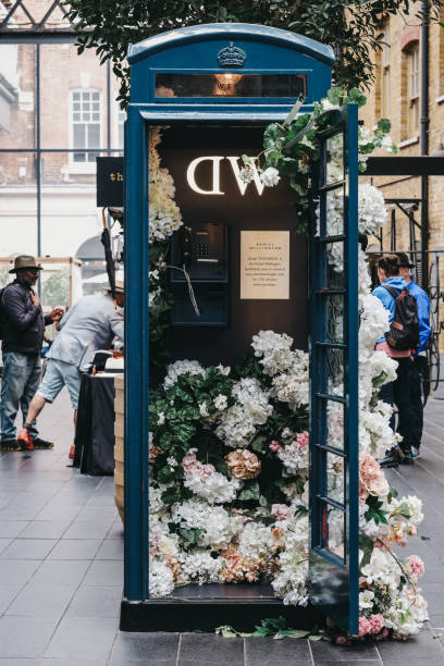 flower urządzone budka telefoniczna sponsorowane przez daniel wellington wewnątrz spitalfields market, londyn, wielka brytania. - capital cities pay phone city cityscape zdjęcia i obrazy z banku zdjęć