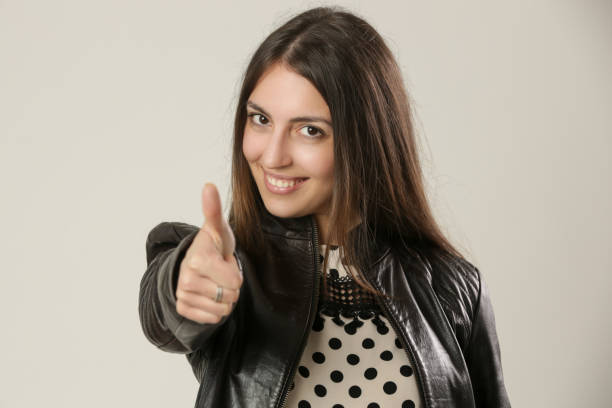 親指を上げる若い女性のスタジオの肖像画 - thumbs up human thumb human finger brown hair ストックフォトと画像
