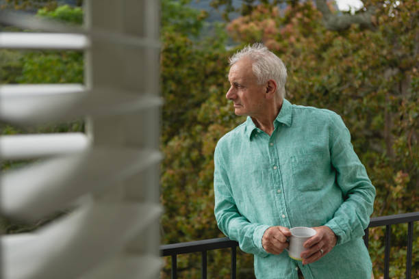 istock Active senior man standing with coffee mug on the balcony 1157334357