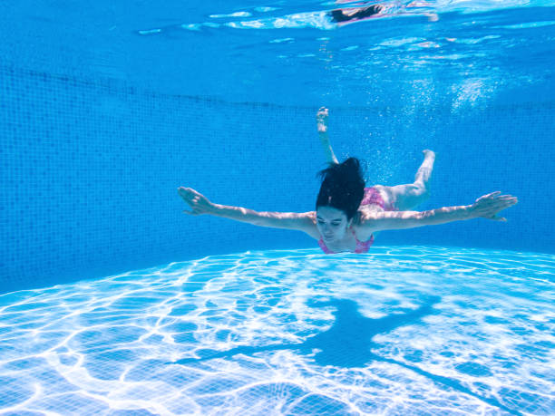 istock Woman Swimming Underwater in Pool 1157336757