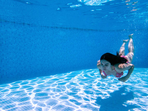 istock Woman Swimming Underwater in Pool 1157336760