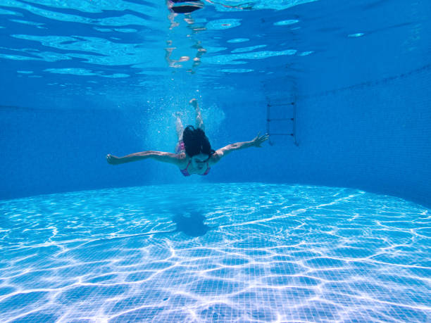 istock Woman Swimming Underwater in Pool 1157336895