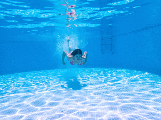 istock Woman Swimming Underwater in Pool 1157336898