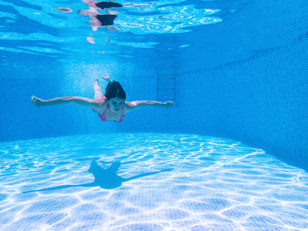 istock Woman Swimming Underwater in Pool 1157337302