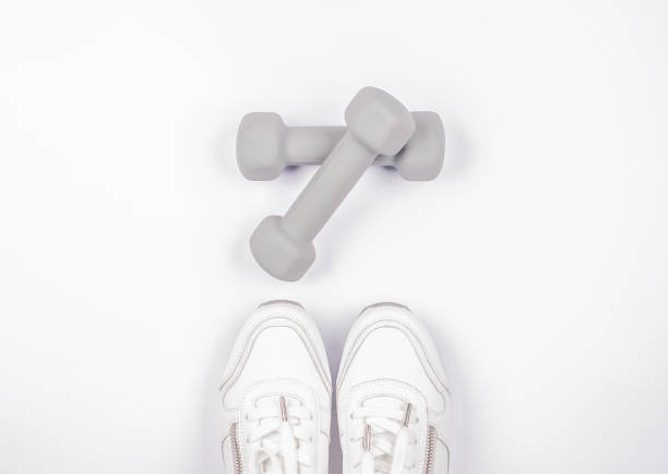 Fashionable White Sport Sneacker with Dumbbell Isolated on White Fashionable White Sport Sneacker with Dumbbell Isolated on White flat shoe photos stock pictures, royalty-free photos & images
