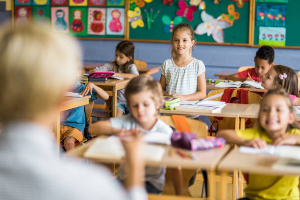 istock Happy schoolgirl having an oral exam during a class at elementary school. 1157339836