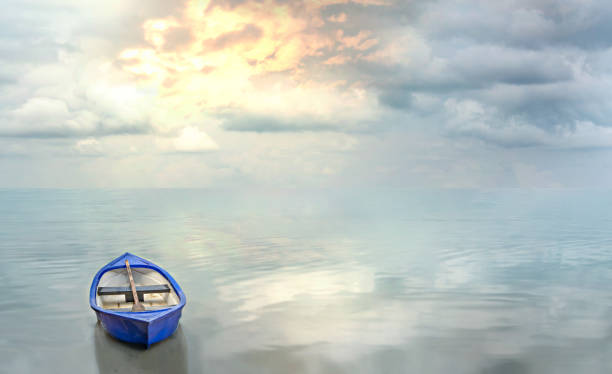 istock blue boat floating on the calm water 1157340388