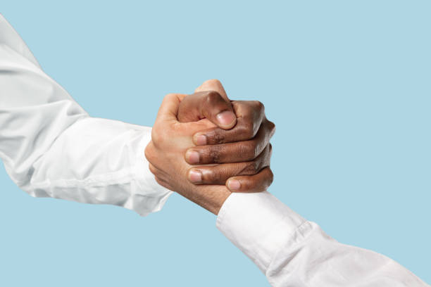 istock Two male hands competion in arm wrestling isolated on blue studio background 1157341910