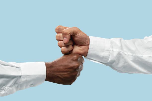 istock Two male hands competion in arm wrestling isolated on blue studio background 1157341912