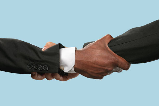 istock Two male hands shaking isolated on blue studio background 1157341940