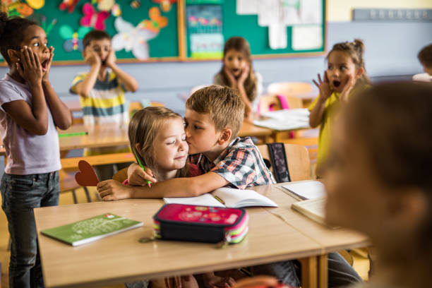 istock Loving elementary student kissing his girlfriend during a class at school. 1157341993