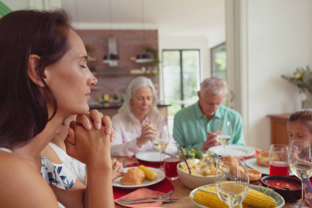 istock Multi-generation family praying before having food on dining table 1157343486