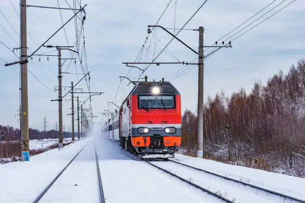Photo of Passenger train approaches to the station at winter morning time.