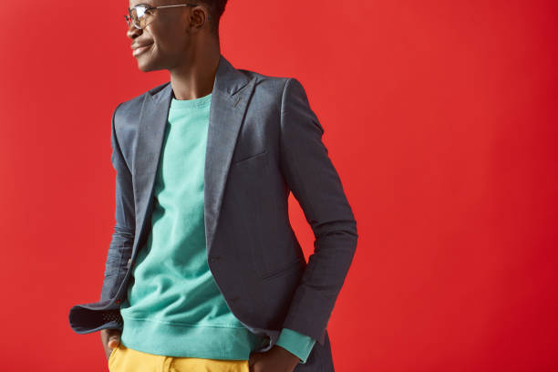 istock Smiling Afro American guy is posing on red background 1157343620