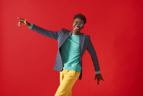 istock Smiling young man in glasses is making dance moves 1157343622