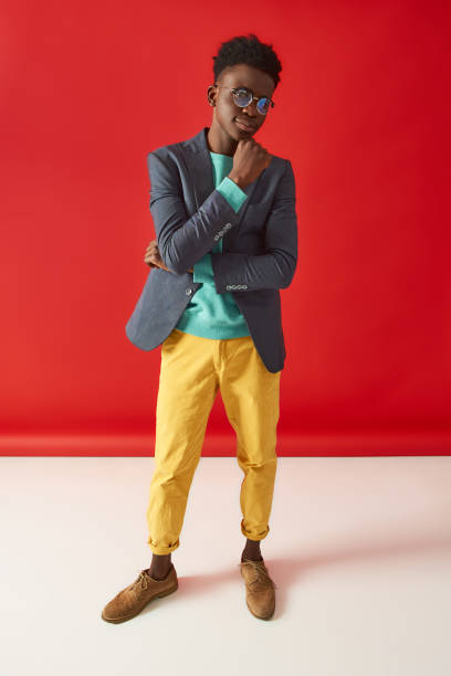 istock Positive young guy in glasses standing on red background 1157343626