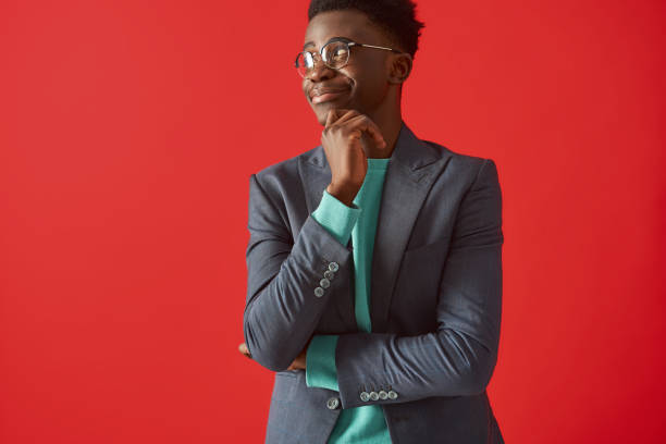 istock Smiling young guy in glasses standing on red background 1157343666