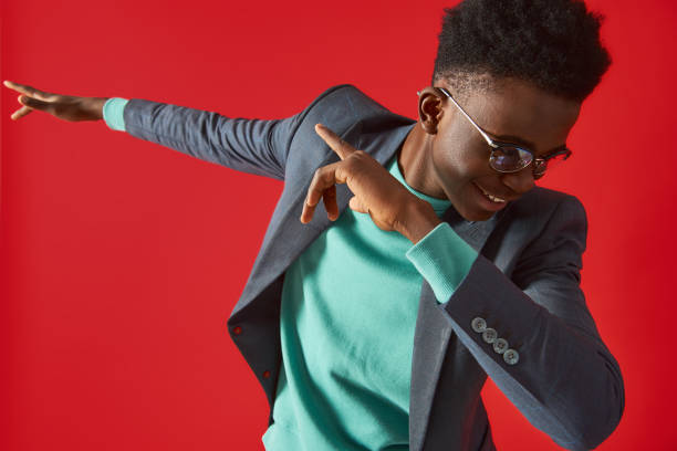 istock Cheerful Afro American man in glasses dancing on red background 1157343677