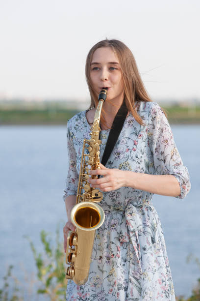 istock Young woman with saxophone in the park 1157343772