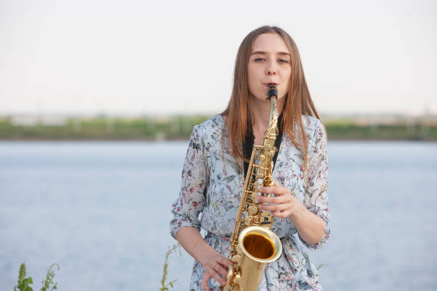 istock Young woman with saxophone with nature background 1157343815