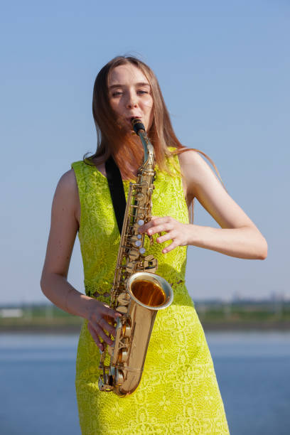 istock Young woman with saxophone in the park 1157343846