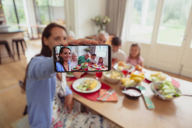 istock Multi-generation family taking selfie with mobile phone while having food on dining table 1157345279