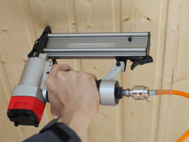 air nailer, stapler travail pneumatique avec commandes à main. carpenter fix clapboard - neumatic photos et images de collection