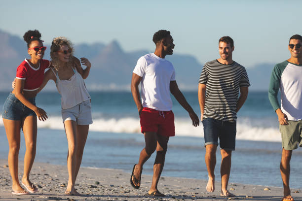 istock Group of friends walking together on the beach 1157346972