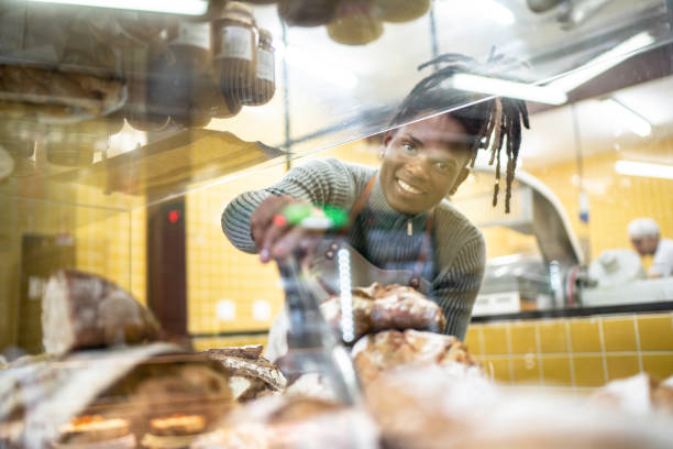 istock Male baker putting breads inside a bag in the bakery 1157350421