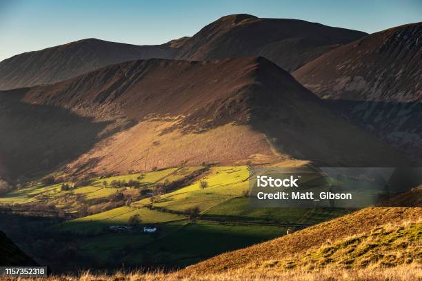 Beautiful Autumn Fall Landscape Image Of Sun Beams Lighting Up Small Area Of Mountain Side In Lake District Whilst Rest Of Area Is In Darkness With Robinson And Dale Head In Background Stock Photo - Download Image Now