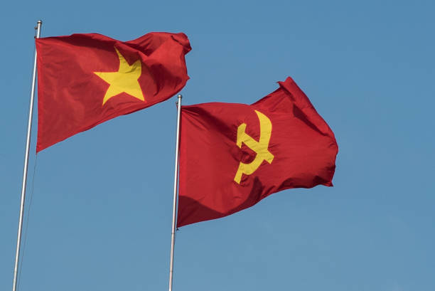 istock Vietnamese and communist flags in the wind 1157353387