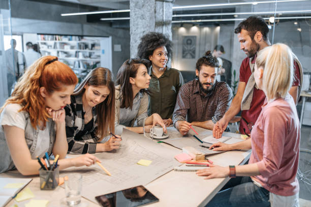 istock Young architects analyzing blueprints on a meeting in the office. 1157353489