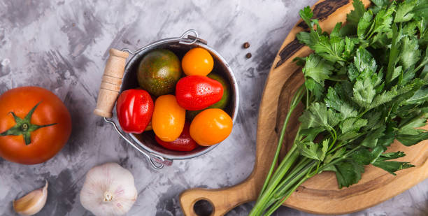 istock Ripe tomatoes for cooking vegetable dish on a gray background 1157353588