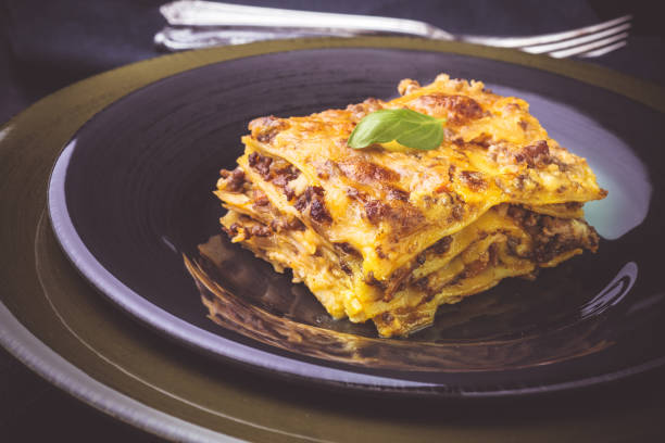 istock Traditional Lasagne with Minced Beef and Green Basil on Dark Plate 1157353626