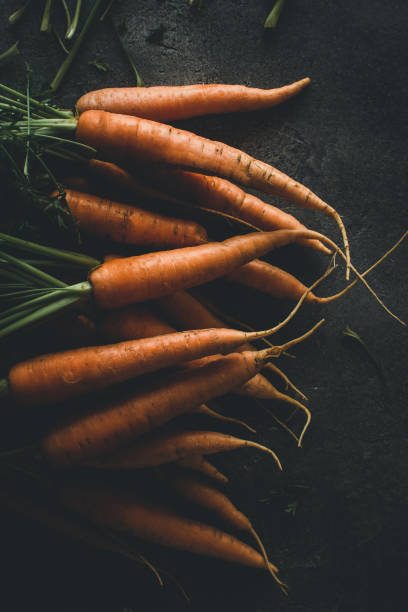 istock Fresh Organic Nantes Carrots on Dark Background 1157353757