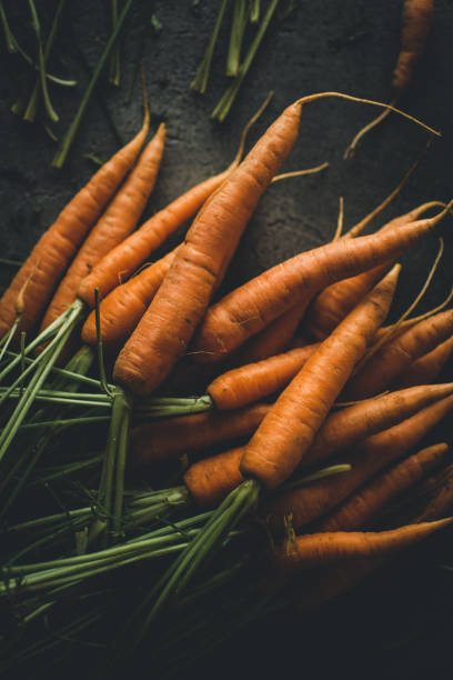 istock Fresh Organic Nantes Carrots on Dark Background 1157354952